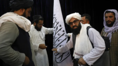 Taliban representatives set up a Taliban flag ahead of a press briefing by Taliban spokesperson Zabihullah Mujahid at the Government Media Information Center in Kabul, Afghanistan on August 17, 2021.