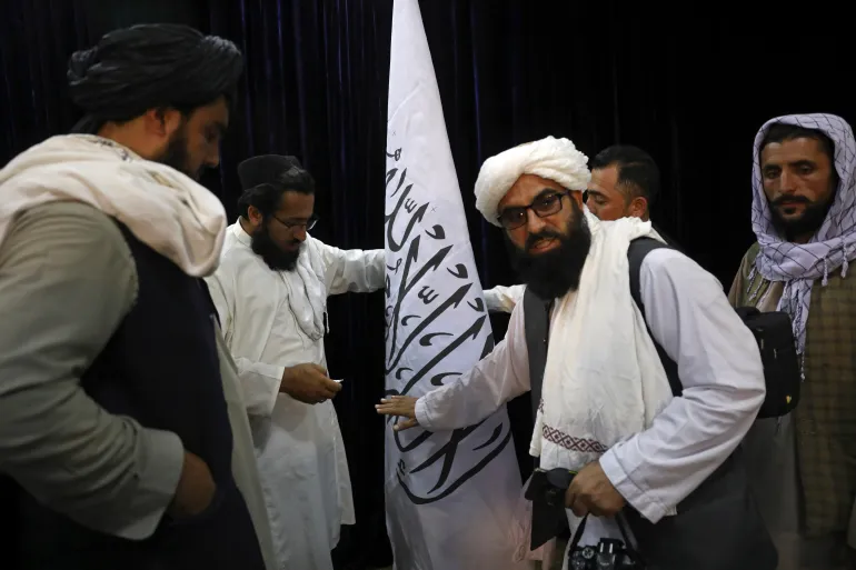 Taliban representatives set up a Taliban flag ahead of a press briefing by Taliban spokesperson Zabihullah Mujahid at the Government Media Information Center in Kabul, Afghanistan on August 17, 2021.