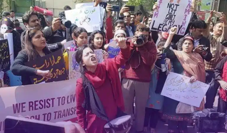 Women are standing with placards at Aurat March in support of Feminism.