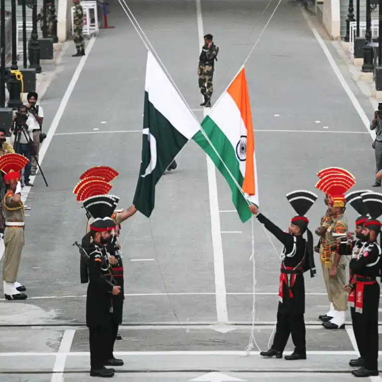 Pakistan-India ties: Pakistani Rangers, clad in black uniforms, and Indian Border Security Force (BSF) officers lower their national flags during a parade at the Pakistan-India joint check-post at Wagah border, near Lahore, Pakistan, on August 14, 2019. (Source: REUTERS/Mohsin Raza)