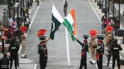 Pakistan-India ties: Pakistani Rangers, clad in black uniforms, and Indian Border Security Force (BSF) officers lower their national flags during a parade at the Pakistan-India joint check-post at Wagah border, near Lahore, Pakistan, on August 14, 2019. (Source: REUTERS/Mohsin Raza)