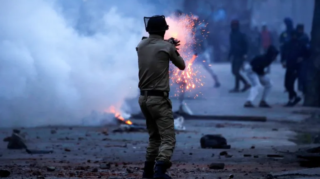 An Indian police officer fires a tear gas shell during a protest in Srinagar last year [File: Danish Ismail/Reuters]