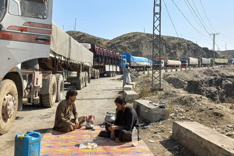 Truck drivers, laden with supplies bound for Afghanistan, pause as they queue at the Torkham border crossing in Pakistan, shut down by Taliban authorities. [Image via Reuters]