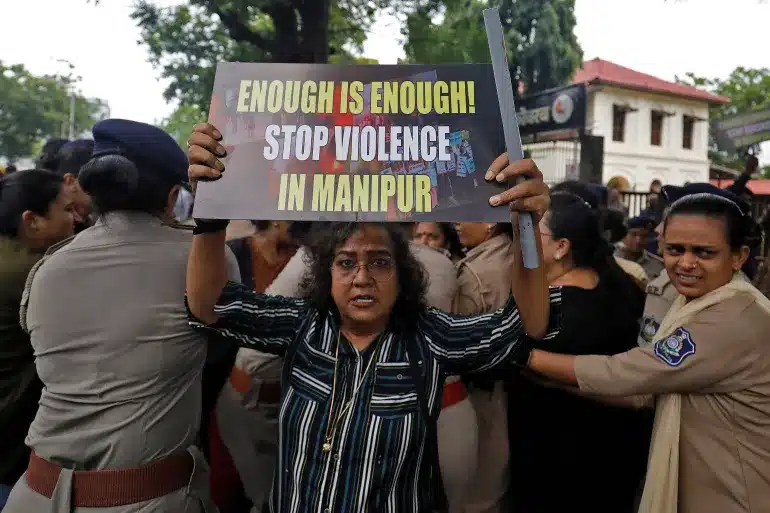 In Ahmedabad, demonstrators protest the alleged sexual assault of two tribal women in Manipur, as police detain others. [Image via Reuters]