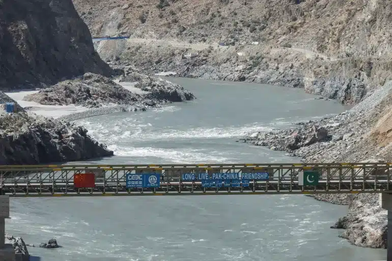 Flags of China and Pakistan fly over a bridge at the Dasu hydropower project site in Khyber Pakhtunkhwa province. [Image via Reuters]