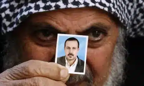 At their home in the Jebaliya refugee camp, northern Gaza Strip, the father of Palestinian militant Mahmoud al-Mabhouh displays a family photo of Mabhouh. [AP]