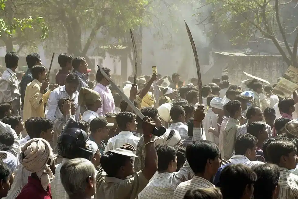 A Hindu mob waves swords at an opposing Muslim crowd during street battles in Ahmedabad [AFP]