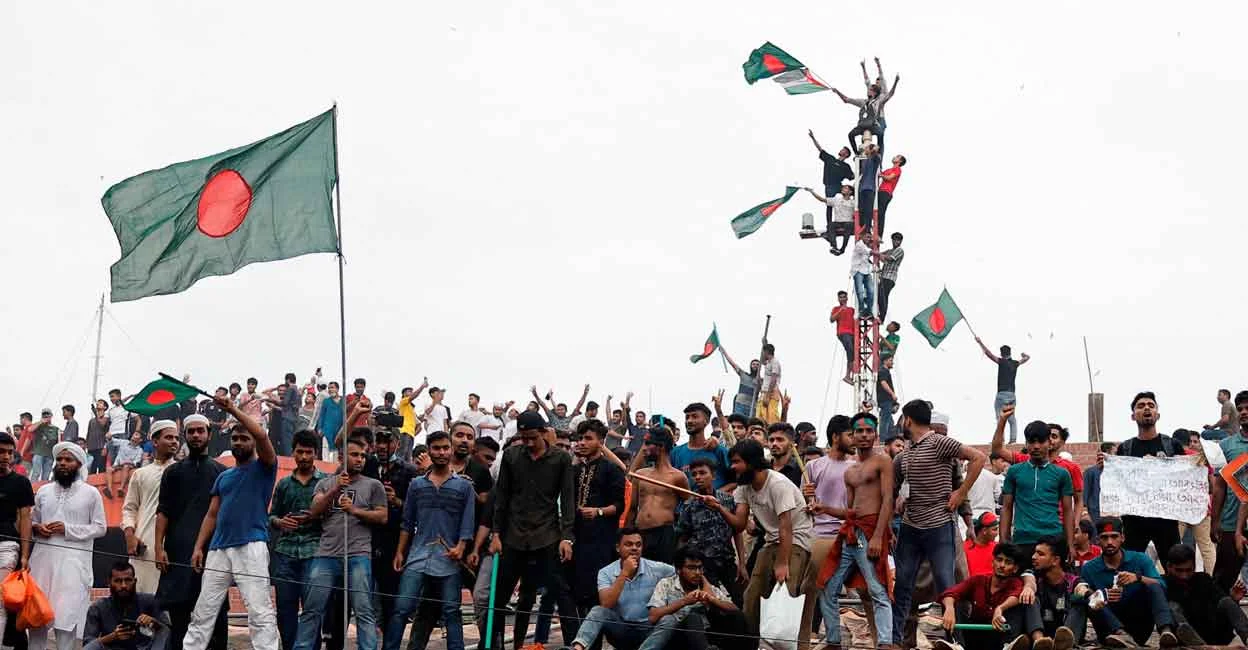 People waves Bangladeshi flags on top the Ganabhaban, the Prime Minister's residence, as they celebrate the resignation of PM Sheikh Hasina in Dhaka, Bangladesh, August 5, 2024. [Reuters]