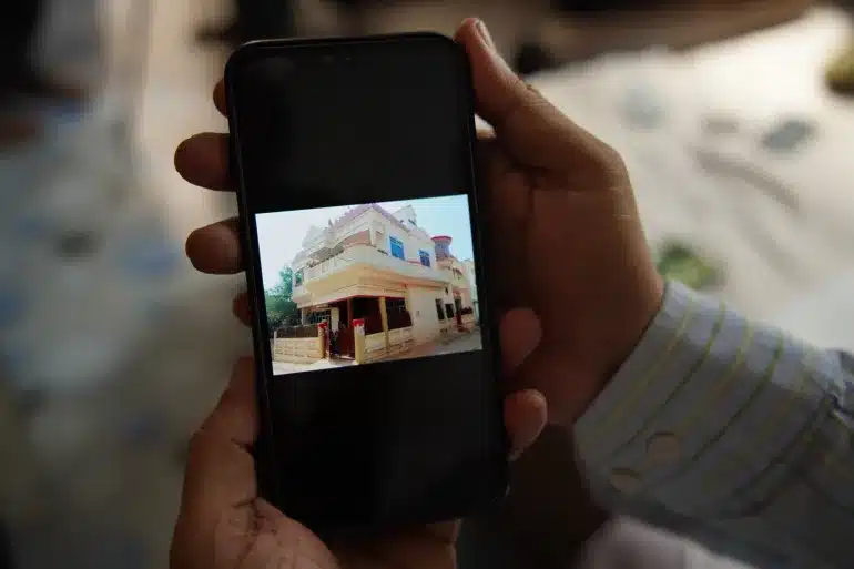 Muslim activist Javed Mohammed showing a photo of his house before it was demolished in Prayagraj, Uttar Pradesh in northern India [Aljazeera]