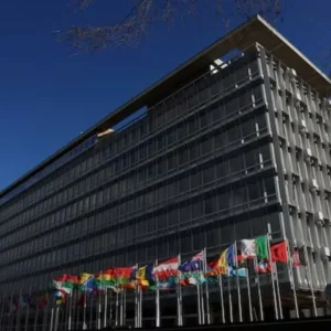 WHO member states discuss a $400 Million budget cut after Trump's decision to withdraw US funding from the global health body. [Image via Reuters]
