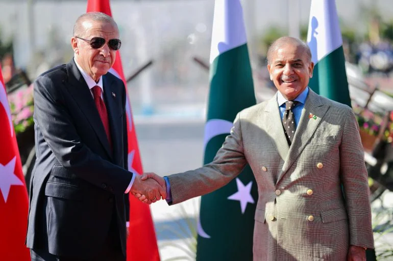 Turkey's President Recep Tayyip Erdogan’s Islamabad stop, shaking hands with Pakistan's Prime Minister Shehbaz Sharif before inspecting a guard of honour during his ceremonial reception at the Prime Minister House in Islamabad [Pakistan's Prime Minister Office / AFP]