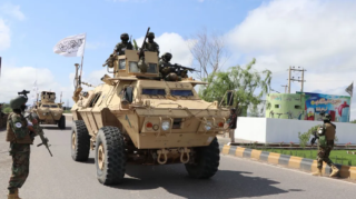 Taliban fighters in armored vehicles, armed with America’s abandoned arsenal in Afghanistan, take part in a military street parade in Herat, Afghanistan, on April 19. [Image via AFP via Getty Images].