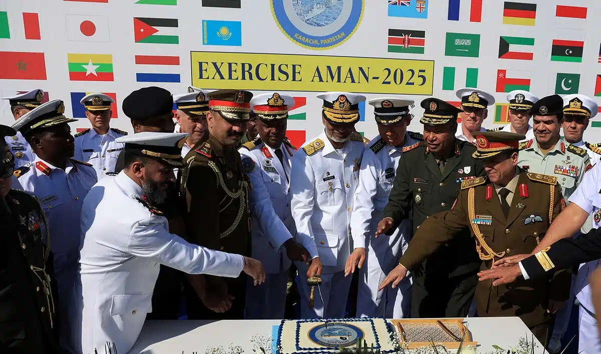 Commander of Pakistan Fleet Rear Admiral Abdul Munib, along with naval commanding officers of participating countries, cut a cake during the opening ceremony of Pakistan Navy’s 9th Multinational Maritime Exercise AMAN-25, under the slogan “Together for Peace,” in Karachi on February 7, 2025. [Image via Arab News / REUTERS].