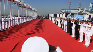 Naval commanding officers of participating countries salute as Pakistan Navy’s servicemen hoist the national flags during the opening ceremony of Pakistan Navy’s 9th Multinational Maritime Exercise AMAN-25, under the slogan “Together for Peace,” in Karachi on February 7, 2025. [Image via Arab News/ REUTERS].