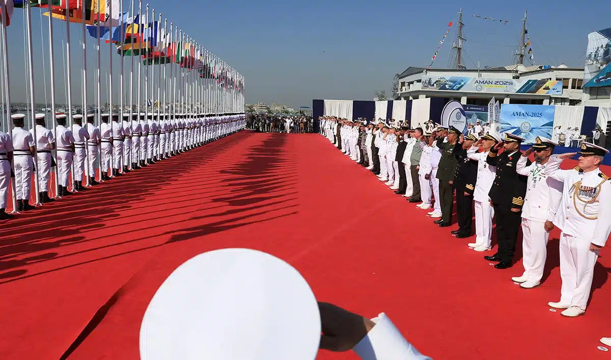 Naval commanding officers of participating countries salute as Pakistan Navy’s servicemen hoist the national flags during the opening ceremony of Pakistan Navy’s 9th Multinational Maritime Exercise AMAN-25, under the slogan “Together for Peace,” in Karachi on February 7, 2025. [Image via Arab News/ REUTERS].