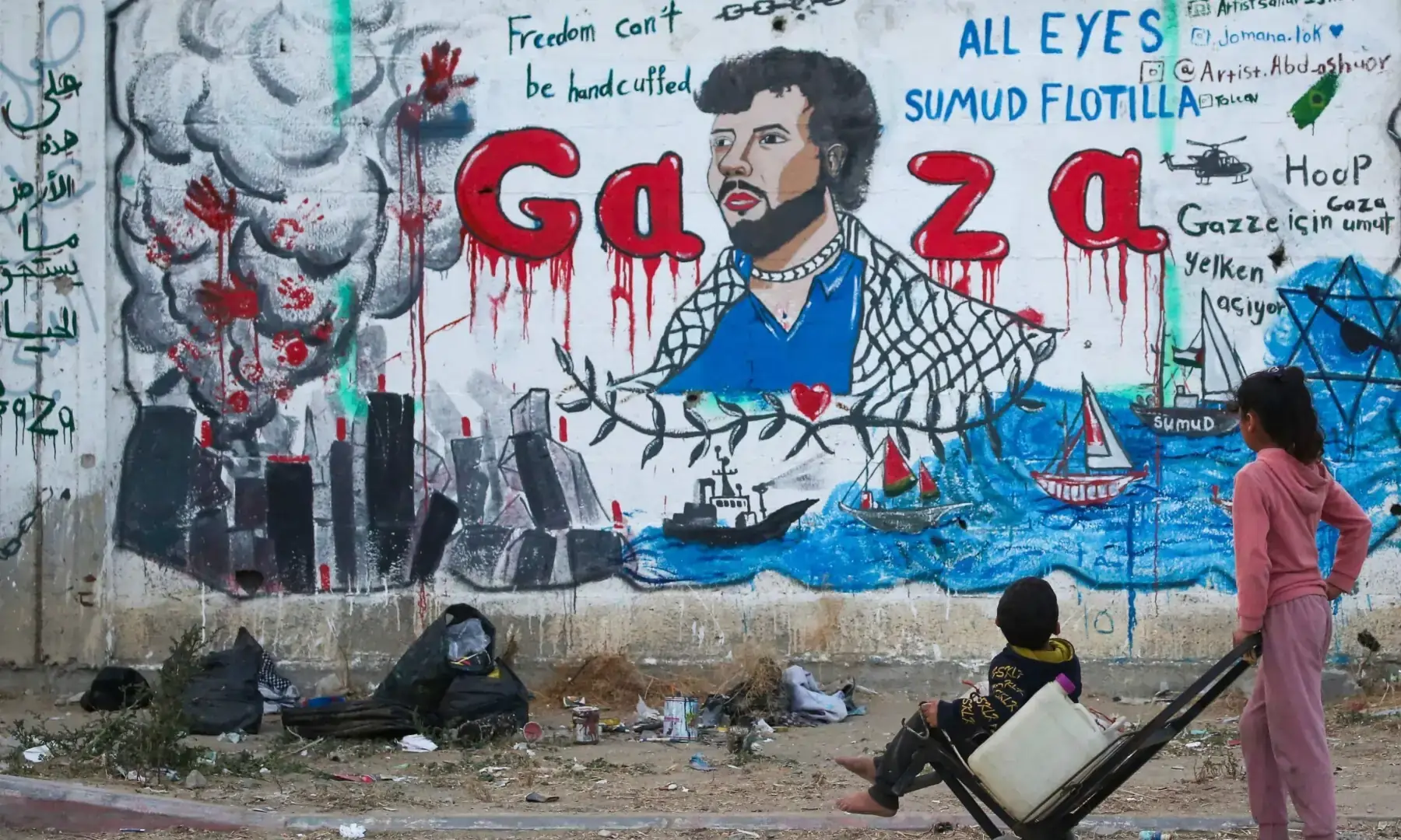 Palestinian children look at a mural depicting Israel's interception of ships participating in the Global Sumud Flotilla, a civilian-led humanitarian aid mission to Gaza by sea