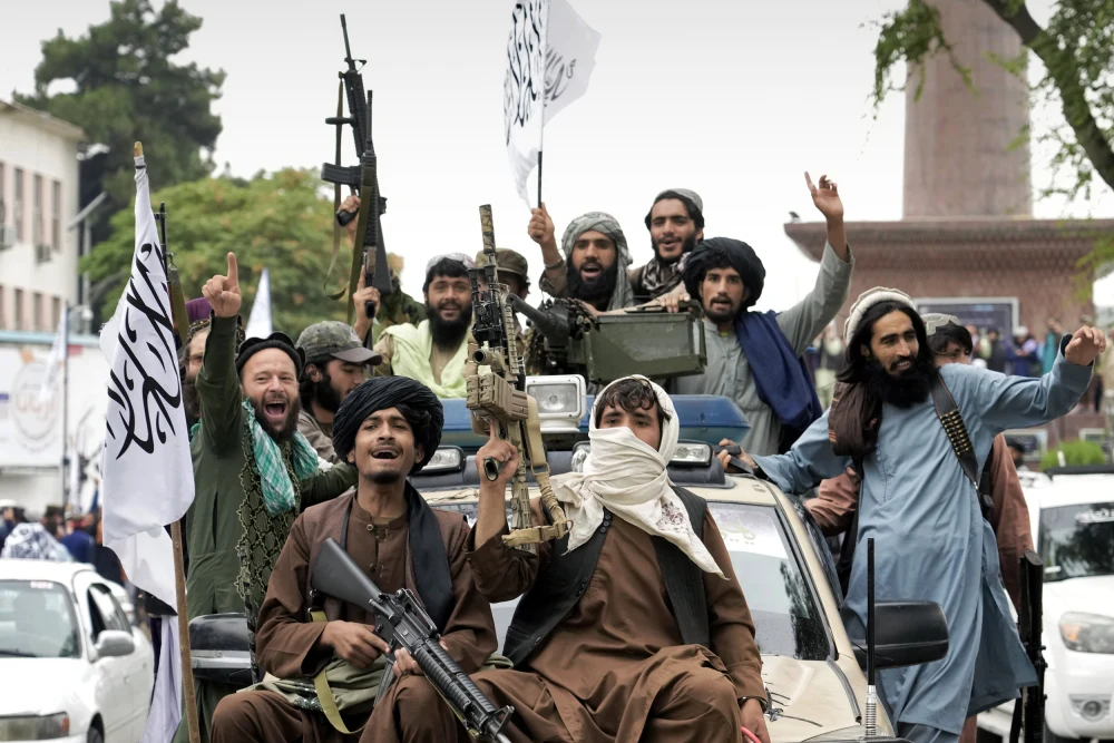Taliban fighters celebrate the first-year anniversary of their takeover in front of the former U.S. Embassy in Kabul.