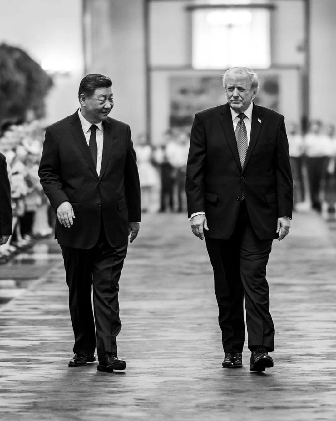 Chinese President Xi Jinping and U.S. President Donald Trump walking side-by-side during a formal diplomatic event in Beijing.