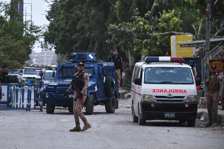 Paramilitary soldiers and police officers stand guard on a road cordoned off near the site of an attack by an armed group at the provincial headquarters of the paramilitary Pakistan Rangers in Karachi, Pakistan, on June 28, 2026 [Ali Raza/AP]
