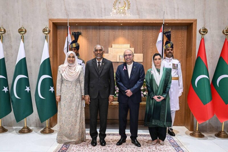 The two Presidents and two First Ladies stand between Maldivian and Pakistani flags at Aiwan-e-Sadr, flanked by ceremonial guards.