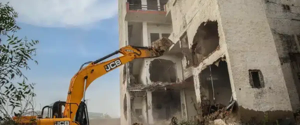 A bulldozer is demolishing a Muslim property in India.